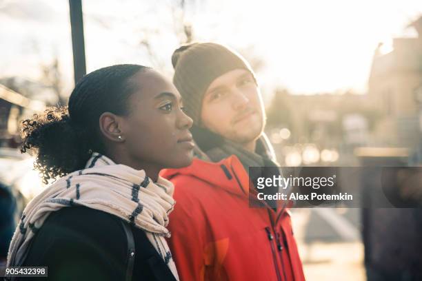 sex tussen verschillendre rassen verliefde paar, de mooie zwarte jonge vrouw en een knappe jongeman, lopen op de straat en plezier in de koude winterdag - alex boys stockfoto's en -beelden