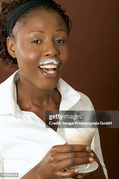 woman drinking latte macchiato, close up - milk moustache stock-fotos und bilder