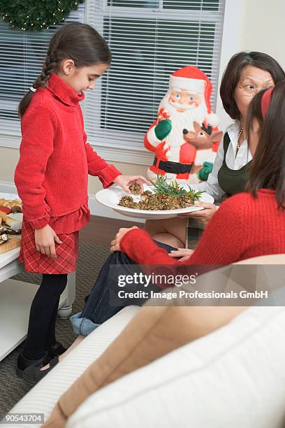 girl (4-5) and two women eating stuffed mushrooms - 45 49 år bildbanksfoton och bilder