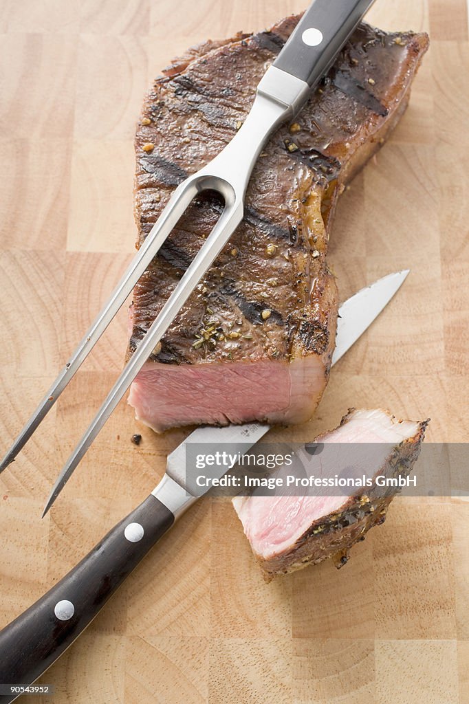 Grilled beef steak with knifes, overhead view