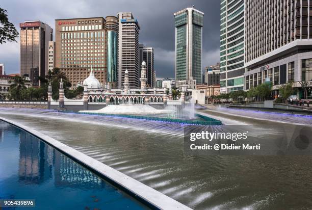 stormy sunset over the masjid jamek mosque in front of office building by the klang river in the heart of kuala lumpur. - masjid jamek stockfoto's en -beelden