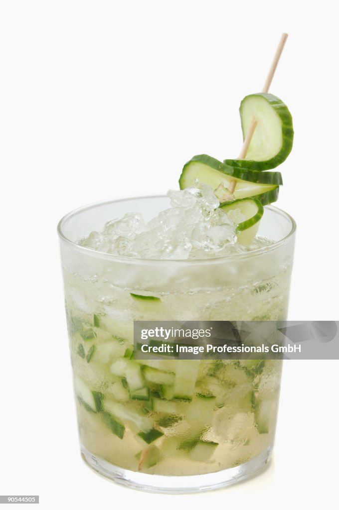 Glass of vodka with cucumber on white background, close up