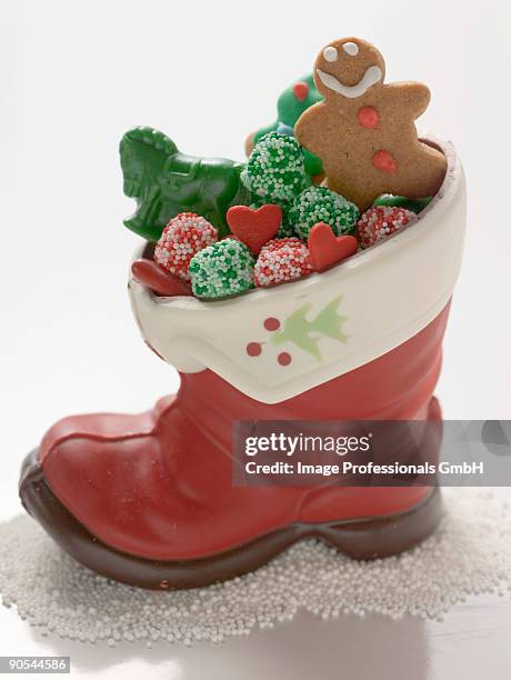 christmas biscuits and sweets in chocolate boot on white background, close up - xmas eps stockfoto's en -beelden