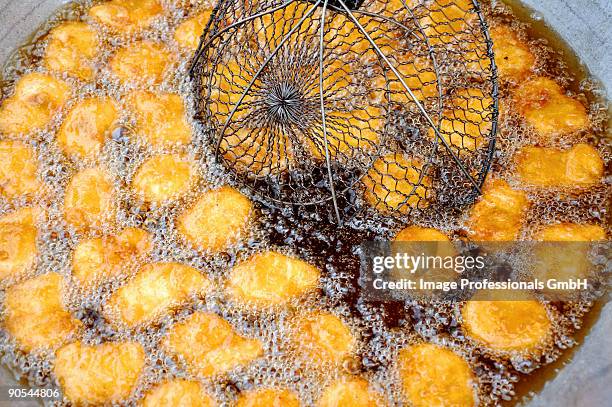 deep-frying tofu in palm oil, close up - schuimspatel stockfoto's en -beelden