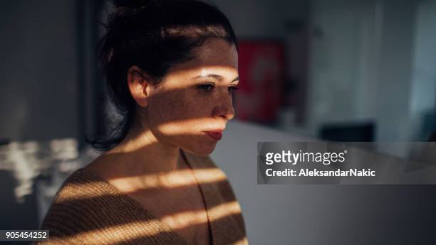 portrait of young woman in her apartment - low self esteem stock pictures, royalty-free photos & images