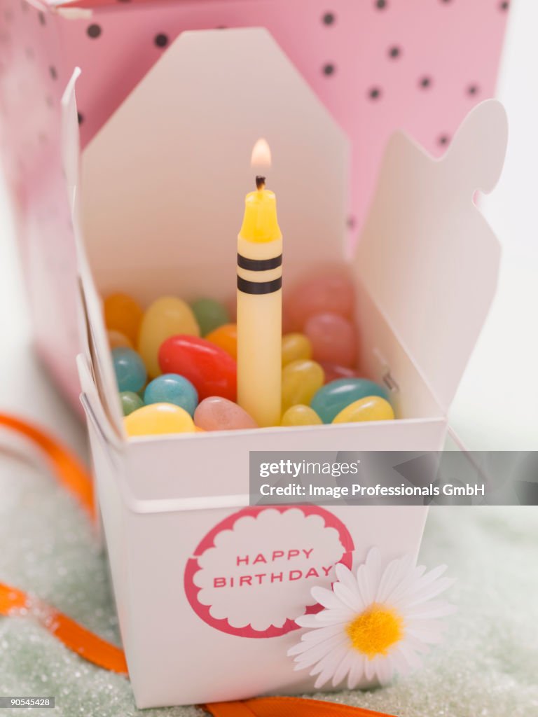 Jelly beans with burning candle for birthday