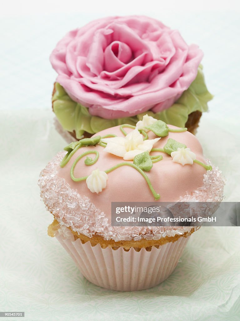 Two cupcakes with flower decorations, close up