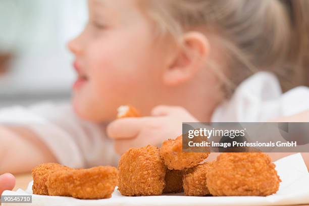 girl (4-5) eating chicken nuggets, close up - eating chicken nuggets stock pictures, royalty-free photos & images
