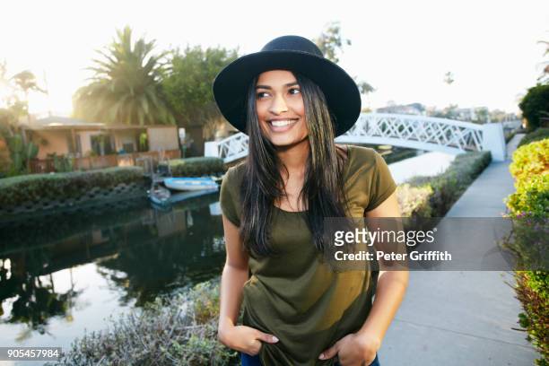 Smiling mixed race woman standing near canal