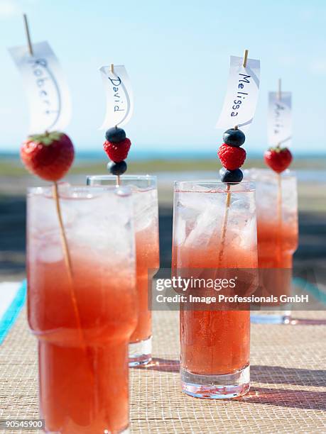 berry cocktails with place cards on cocktail sticks, close up - 4 cocktails stockfoto's en -beelden