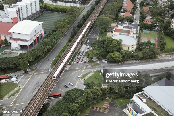 Traffic drives along a road under a SMRT Corp. Train travelling along an elevated track in Queenstown estate in Singapore, on Monday, Jan 15, 2018....