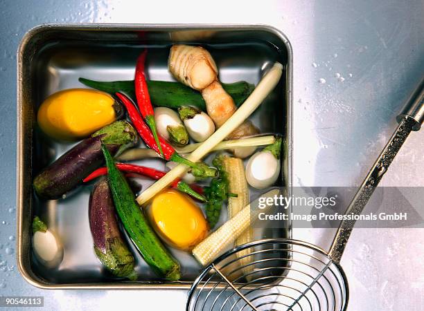 vegetable in tray beside straining spoon, close up - schuimspatel stockfoto's en -beelden