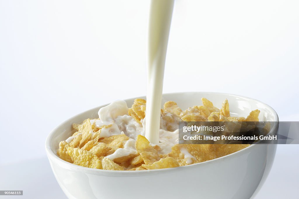 Pouring milk over cornflakes, close up