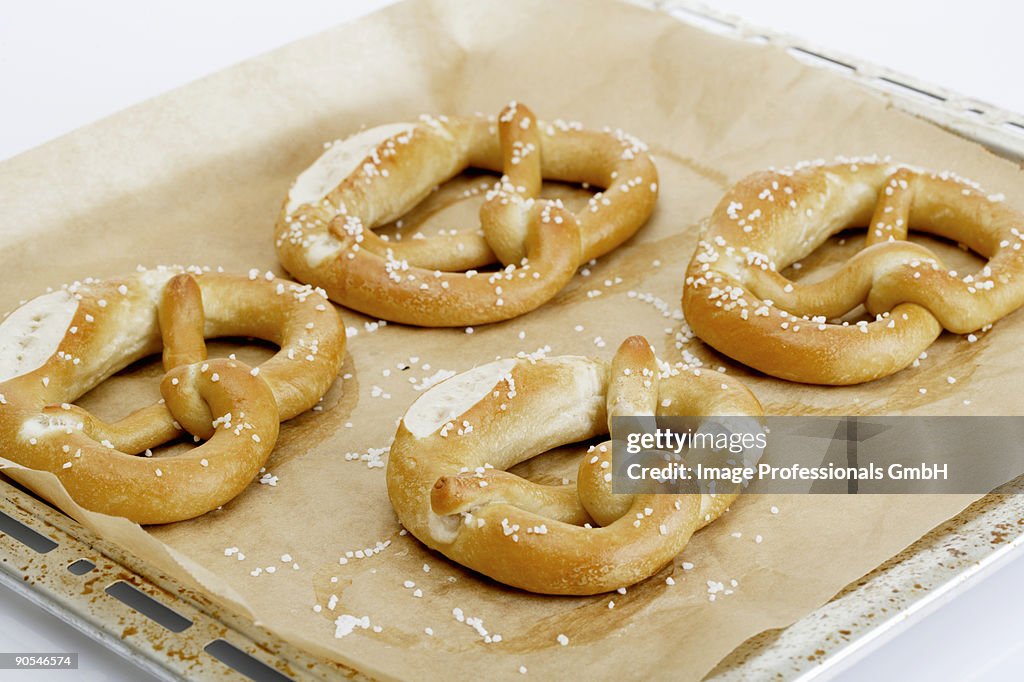 Four pretzels on baking tray, close up