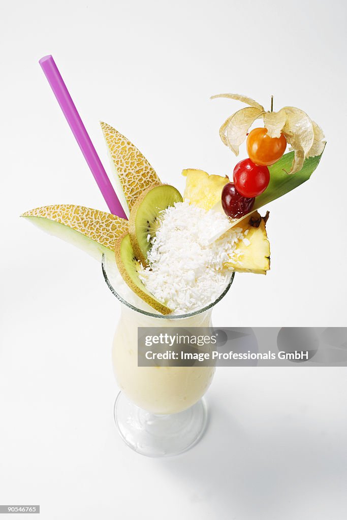 Pina colada garnished with fruit and grated coconut, close Up