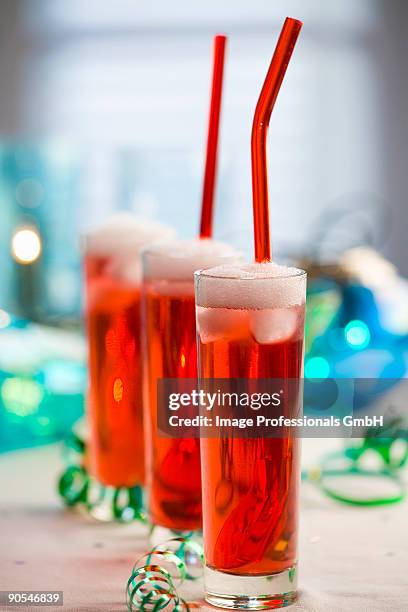 champagne with strawberry syrup and ice cubes, close up - strawberry syrup stock pictures, royalty-free photos & images