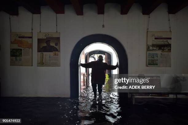 An Indonesian firefighter wades through water as they work to extinguish a fire inside the 17th-century Dutch colonial building maritime museum in...