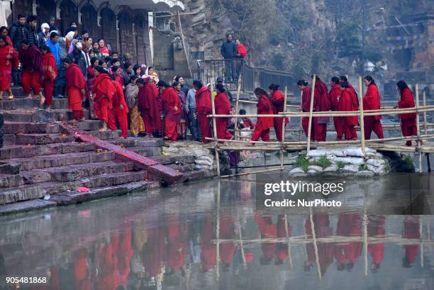 Nepalese Hindu Devotees lining to take holy water from Bagmati River at Pashupathnath Temple, Kathmandu during Madhav Narayan Festival or Swasthani...