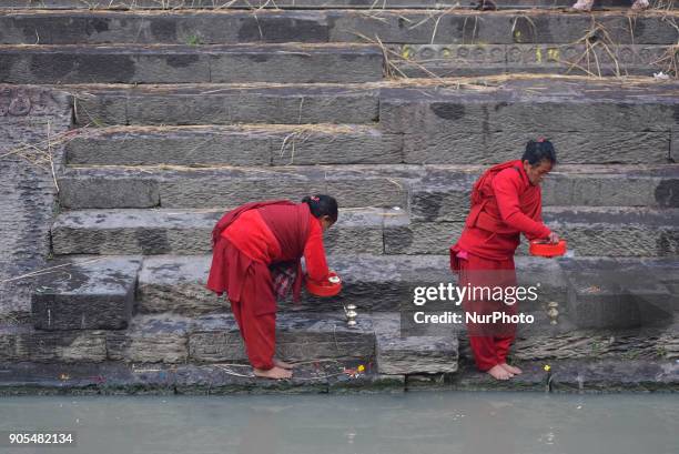 Nepalese Hindu woman offering ritual prayer at Pashupathnath Temple, Kathmandu during Madhav Narayan Festival or Swasthani Brata Katha on Tuesday,...