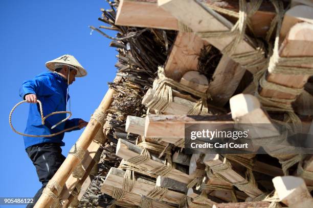 Man ties rope during construction of the shrine during preparations for the Nozawaonsen Dosojin Fire Festival on January 15, 2018 in Nozawaonsen,...