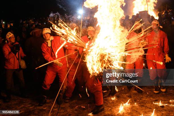 Men carry flaming sticks as they try to set fire to a wooden shrine that is protected by men from Nozawaonsen village during the Nozawaonsen Dosojin...