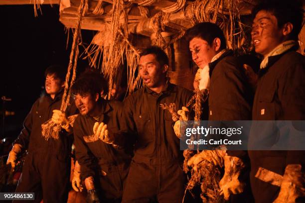 Young men from Nozawaonsen village who are tasked with protecting the wooden shrine pause between attacks by people trying to set fire to it during...