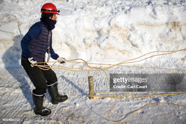 Man prepares rope for use in the construction of the shrine during preparations for the Nozawaonsen Dosojin Fire Festival, on January 14, 2018 in...