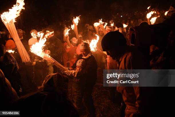 Woman helps her child carry a flaming stick during the Nozawaonsen Dosojin Fire Festival on January 15, 2018 in Nozawaonsen, Japan. The festival is...