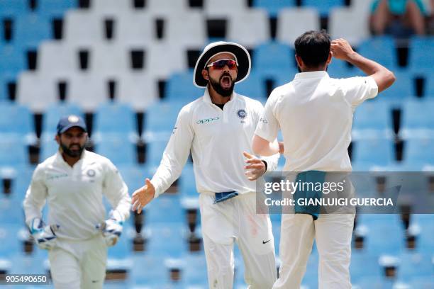 Indian bowler Mohammed Shami and Captain Virat Kohli celebrate the dismissal of South African batsman Quinton de Kock during the fourth day of the...