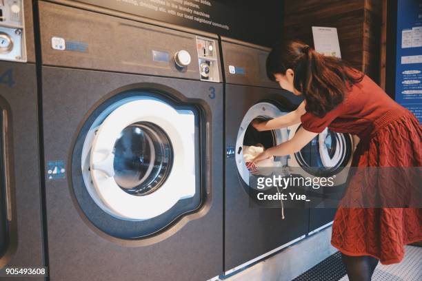 jonge vrouw doen van wasserij - wasserglas stockfoto's en -beelden