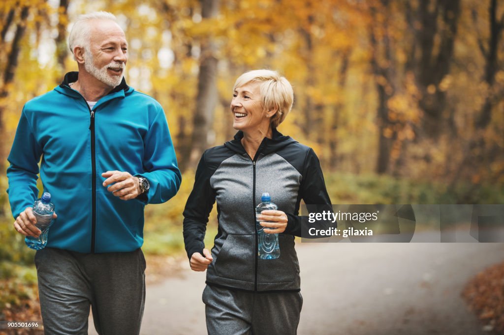 Senior couple jogging in a forest.