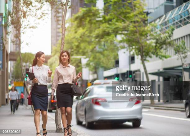 twee zakelijke vrouwen wandelen langs stad straat in sydney - sydney street stockfoto's en -beelden