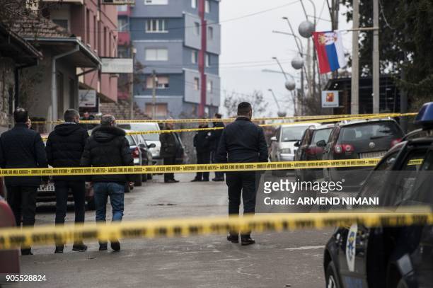 Kosovo police officers and forensics walk paste the crime scene where the leading Kosovo Serb politician Oliver Ivanovic was killed in a brazen...