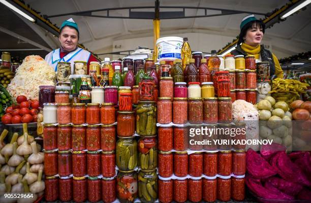 Two vendors sell jars pickled and spiced vegetables at a food market in Moscow on January 16, 2018.