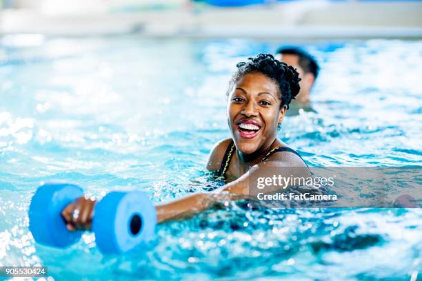 swimming with weights - indoor swimming pool stock pictures, royalty-free photos & images