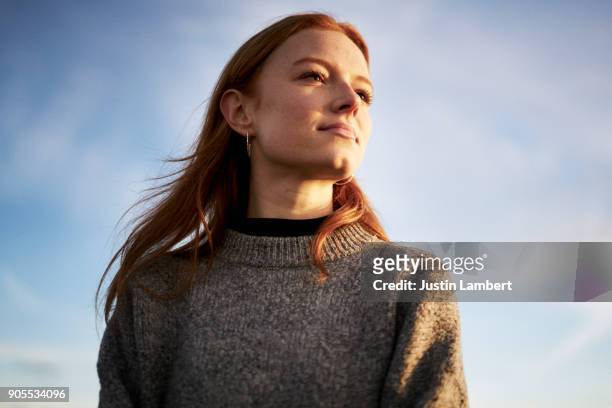 young lady looking content in the winter sunshine - guardare in una direzione foto e immagini stock