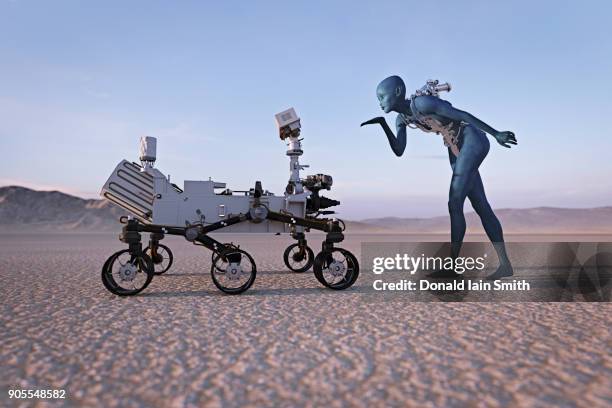 futuristic woman blowing a kiss to robot in desert - a journey to planet sanity stockfoto's en -beelden