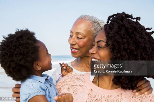 black family hugging on beach - los angeles beach stock-fotos und bilder