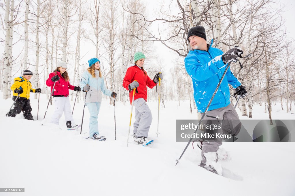 Caucasian family snowshoeing in winter