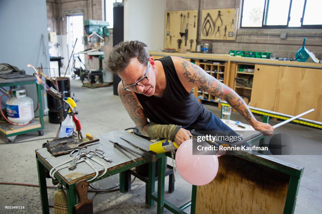 Caucasian man shaping glass