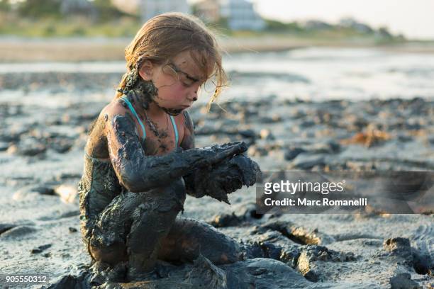 caucasian girl covered in mud playing on beach - people covered in mud stock pictures, royalty-free photos & images