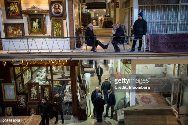 Vendors wait for customers to sell Persian carpets and framed pictures in the rug bazaar in Tehran, Iran, on Monday, Jan. 15, 2018. The U.S....