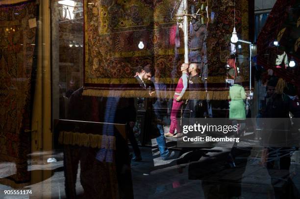 The window of a carpet store reflects shoppers visiting the rug bazaar in Tehran, Iran, on Monday, Jan. 15, 2018. The U.S. President plans on...