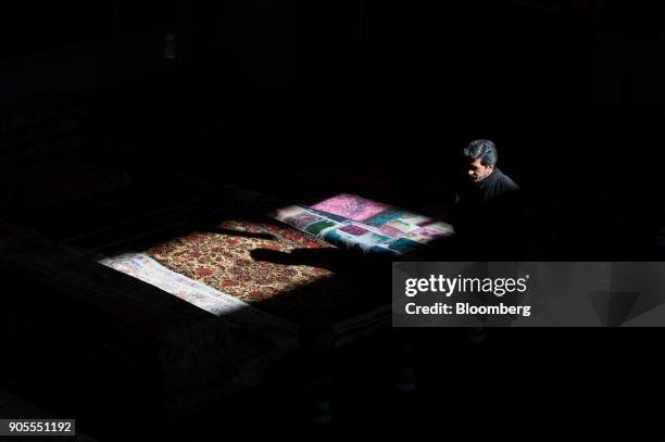 The shadow of a man falls on a Persian carpet layed out in the rug bazaar in Tehran, Iran, on Monday, Jan. 15, 2018. The U.S. President plans on...