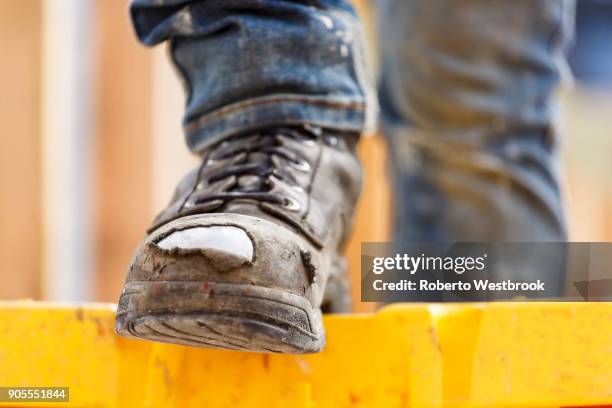 warn boot of caucasian woman at construction site - woman boots fotografías e imágenes de stock
