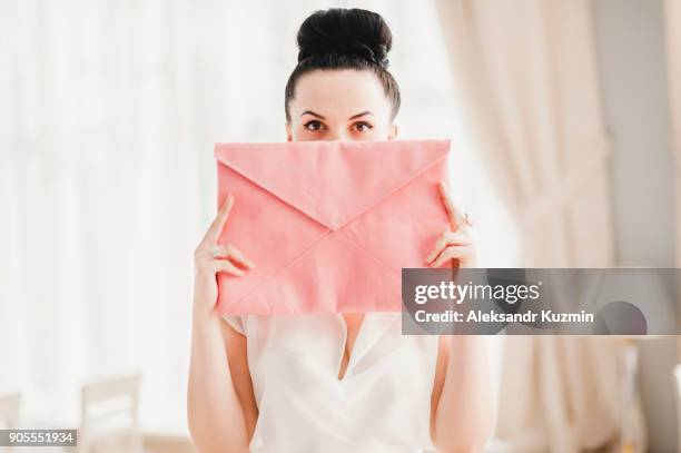 glamorous middle eastern woman covering face with pink purse - gesicht verstecken stock-fotos und bilder