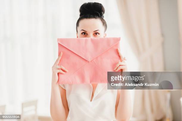 glamorous middle eastern woman covering face with pink purse - eastern european woman stockfoto's en -beelden