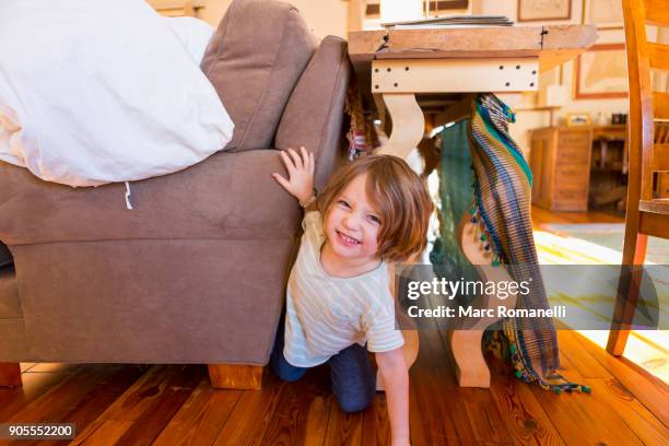 caucasian boy crawling on floor between table and sofa - kids fort stock pictures, royalty-free photos & images