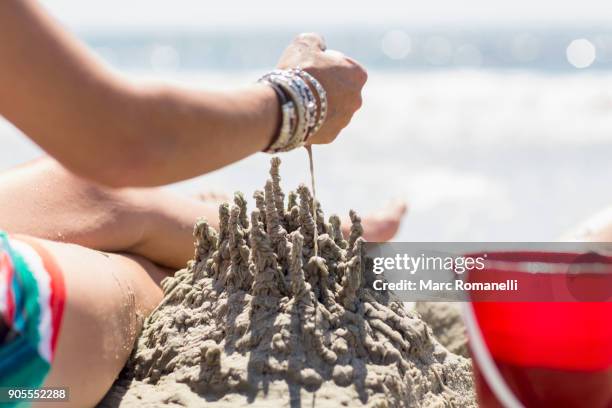 caucasian woman playing with sand castle at beach - saint simons island stockfoto's en -beelden