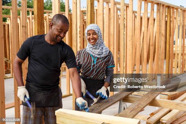 black volunteers building house - volunteer building stock pictures, royalty-free photos & images